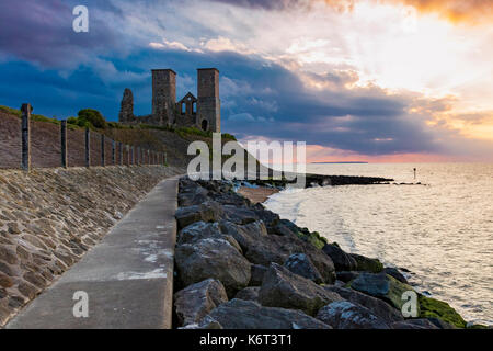 Torri reculver contro un tramonto spettacolare sky, con dark nuvole temporalesche attraverso l'estuario del Tamigi, reculver, kent, Regno Unito Foto Stock