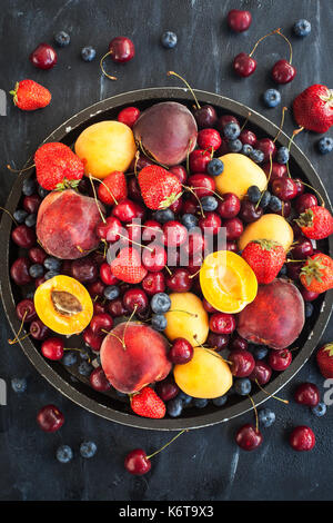 Matura fresca estate di bacche e frutta (pesche, albicocche, ciliegie e fragole) sul vassoio Foto Stock