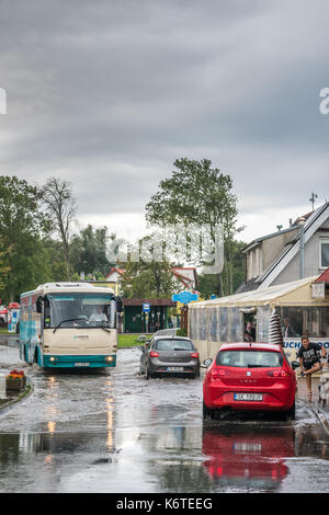 Sarbinowo, Polonia - Agosto 2017 : autobus e automobili private attraversando la strada allagata dopo estremamente forti precipitazioni Foto Stock