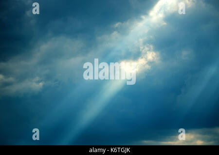 Raggi di sole cadere dalle nuvole Foto Stock