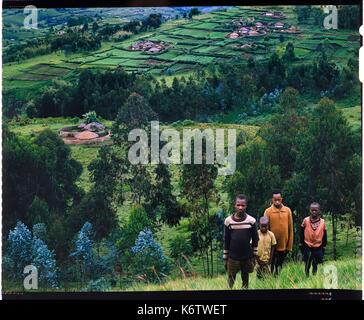 Burundi, provincia di Bujumbura, area Ijenda, gruppo di bambini Tutsi, habitat è diffusa in modo casuale intorno alle colline e che dà il Burundi paesaggi un aspetto unico, ci sono le piantagioni di tè intorno al rugos (4x5 inversione di riproduzione di film) Foto Stock