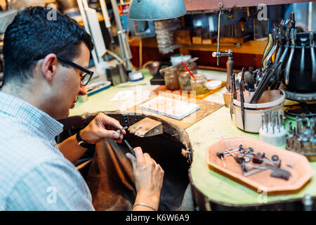 Goldsmith lavorando sul suo banco Foto Stock