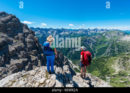 Due escursionisti con vista sulle montagne e sulle Alpi, sentiero escursionistico per Hochvogel, Allgäu, Allgäuer Hochalpen, Baviera, Germania Foto Stock