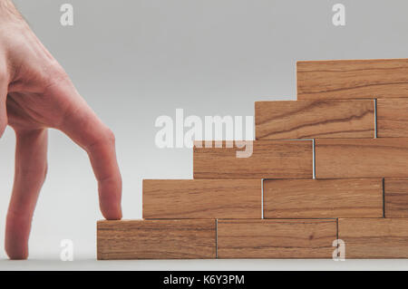 Persone mano a camminare su un insieme di blocchi di legno. lo sviluppo del business e la crescita concetto Foto Stock