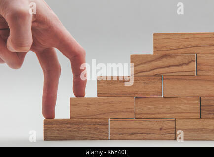 Persone mano a camminare su un insieme di blocchi di legno. lo sviluppo del business e la crescita concetto Foto Stock