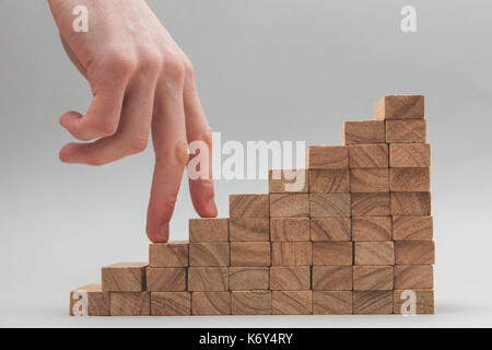 Persone mano a camminare su un insieme di blocchi di legno. lo sviluppo del business e la crescita concetto Foto Stock