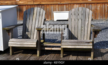 Weathered adirondack sedie e tavolo su un dock Foto Stock