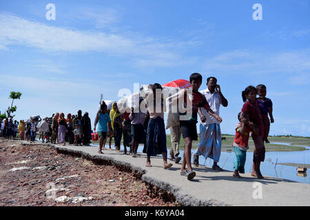 Coz's bazer, bangladesh - Settembre 11, membri del Myanmar musulmano della minoranza Rohingya a piedi attraverso una strada rotto a shah porir profonda, a teknaf in cox' Foto Stock