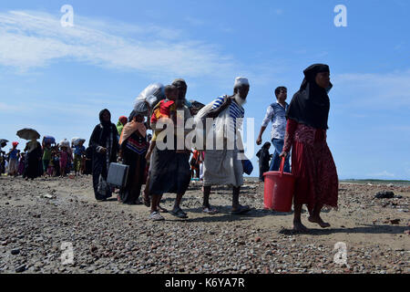 Coz's bazer, bangladesh - Settembre 11, membri del Myanmar musulmano della minoranza Rohingya a piedi attraverso una strada rotto a shah porir profonda, a teknaf in cox' Foto Stock