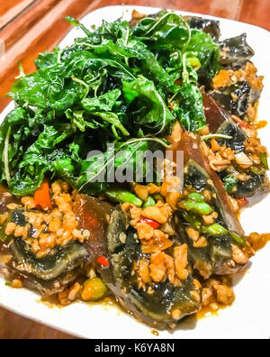 Frittura di mille anni di uovo con croccante di santo le foglie di basilico e il piatto di riso su una tavola di legno sfondo, piccante tradizionale popolare thai autentica signatur Foto Stock