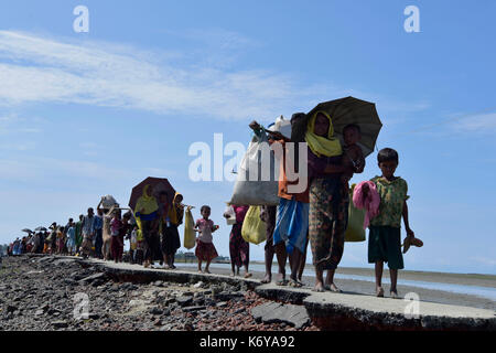 Coz's bazer, bangladesh - Settembre 11, membri del Myanmar musulmano della minoranza Rohingya a piedi attraverso una strada rotto a shah porir profonda, a teknaf in cox' Foto Stock