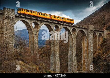 Francia, Pirenei orientali, parco naturale regionale dei Pirenei catalani, Tet Valley, Sejourne bridge, Le Train Jaune, pioggia attraversando il ponte Sejourne in inverno Foto Stock