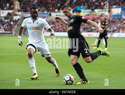 Swansea City's jordan ayew (sinistra) e il Newcastle United's ciaran clark (destra) battaglia per la sfera Foto Stock