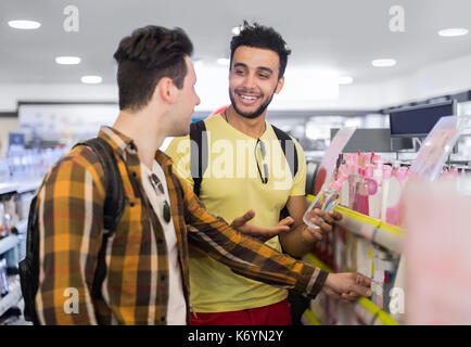 Giovane uomo giovane nel supermercato scegliendo prodotti sorridenti ragazzi acquisto shop interno Foto Stock