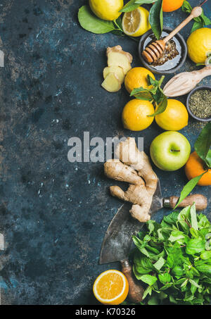 Ingredienti per rendere flu lotta naturale bevanda calda. le arance, menta, limoni, zenzero, miele, apple e spezie su sfondo di legno compensato, vista dall'alto, copia Foto Stock