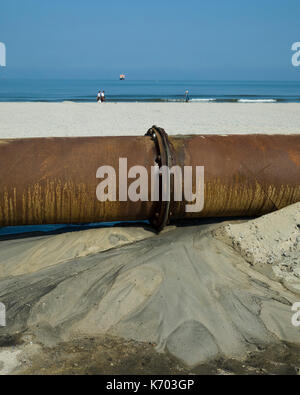 Am Strand, Langeoog. Deutschland. Germania. Parte delle condutture industriali utilizzati come parte della spiaggia di attivo in fase di ricostruzione Strandaufschüttung, sabbia di pompaggio su spiagge di sabbia. Un close-up di un giunto in pipeline che mostra una perdita di acqua. Foto Stock