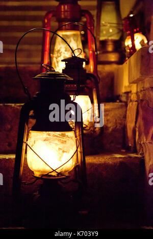 In vecchio stile lampade ad olio o lanterne seduto su una rampa di scale di notte Foto Stock