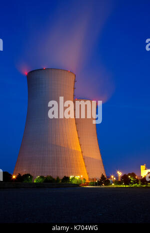 Due alte torri di raffreddamento di una centrale nucleare con la notte blu del cielo. Foto Stock