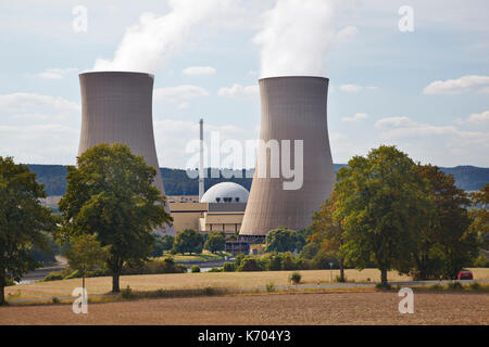 Due alte torri di raffreddamento e il reattore di costruzione di una centrale nucleare nel fiume verde paesaggio visto da una collina. Foto Stock