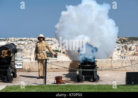 Un giovane gunner incendi per Malta il cannone di mezzogiorno per contrassegnare l'ora di mezzogiorno. Il cannone di mezzogiorno salute è una vecchia tradizione navale che re-è stato istituito nel 2004 e OC Foto Stock