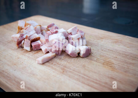 Bacon fresco sul tagliere di legno Foto Stock