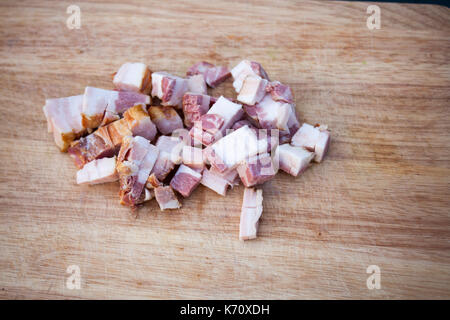 Bacon fresco sul tagliere di legno Foto Stock