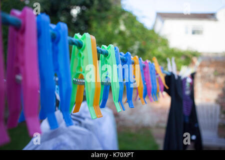 Vestiti di plastica pioli posa sul filo. Foto Stock