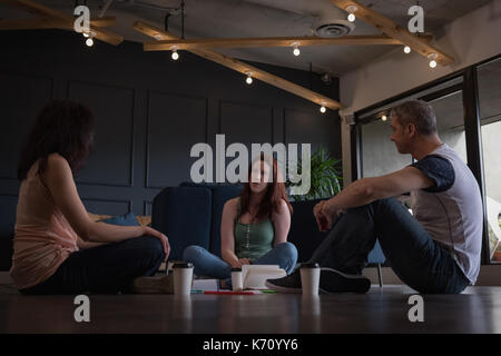 La gente di affari una conversazione mentre è seduto sul pavimento in office Foto Stock