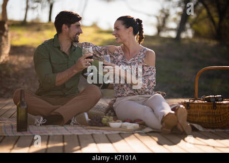 Coppia felice la tostatura di bicchieri di vino durante la vacanza di safari Foto Stock
