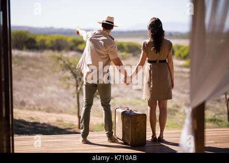 Vista posteriore del giovane puntando alla vista in una giornata di sole durante la vacanza di safari Foto Stock