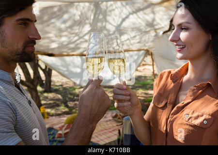 Coppia giovane tostare champagne flauti in tenda Foto Stock