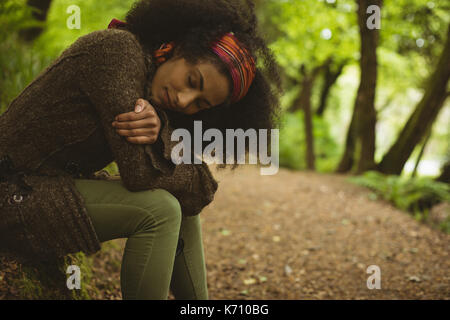 Vista laterale della giovane donna che dorme al forest Foto Stock