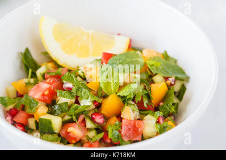 Insalata tabulé, rustico sfondo concreto, bianco ciotola, piatto arabo. Foto Stock