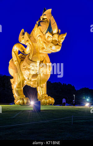 CHIANG RAI, Thailandia-OCT. 27 2016: oro Singha statua a Singha Park è il simbolo di Boon Rawd casale circondato da sotto i riflettori durante il crepuscolo o Foto Stock