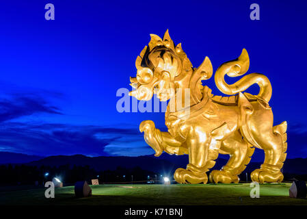 CHIANG RAI, Thailandia-OCT. 27 2016: oro Singha statua a Singha Park è il simbolo di Boon Rawd casale circondato da sotto i riflettori durante il crepuscolo o Foto Stock