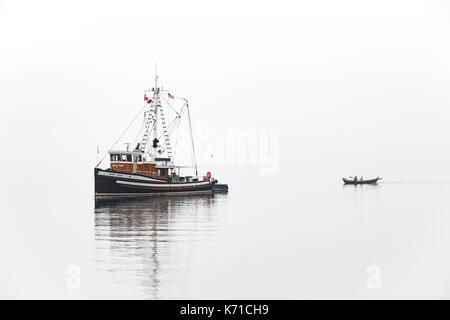 Barca da pesca vicino a Port Townsend durante la barca di legno mostra nella nebbia con barca a remi. Foto Stock