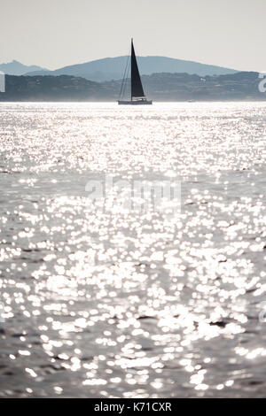 Barche a vela di lusso sul mare contro il sole riflessioni sul mare con cielo blu chiaro Foto Stock
