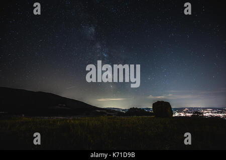 Bellissima vista della via lattea su un campo con balle di fieno Foto Stock