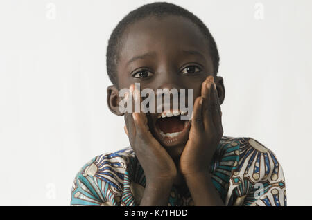 Little Black boy sorpreso ed entusiasmato con bianco sfondo isolato Foto Stock