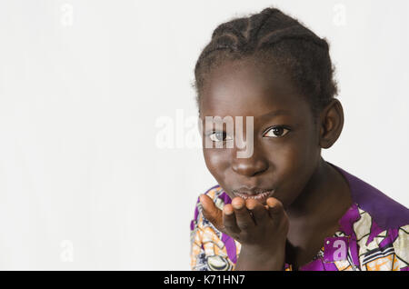 Bella ragazza africana soffia un bacio, isolato su bianco Foto Stock