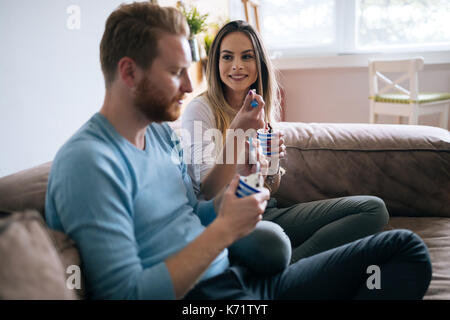 Coppia romantica a mangiare il gelato insieme e guardare la tv Foto Stock