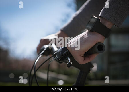 Tagliate le mani di uomo con bicicletta durante la giornata di sole Foto Stock