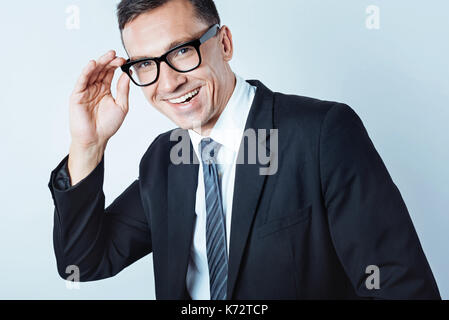 Emozionato l'uomo d'affari in posa di occhiali Foto Stock