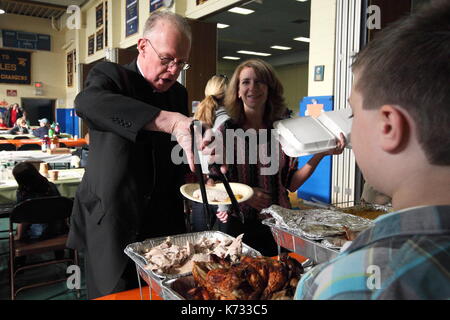 Un sacerdote mangia la cena di ringraziamento a Saint Charles scuola sul rendimento di grazie in Staten Island, New York il 22 novembre 2012. Foto Stock