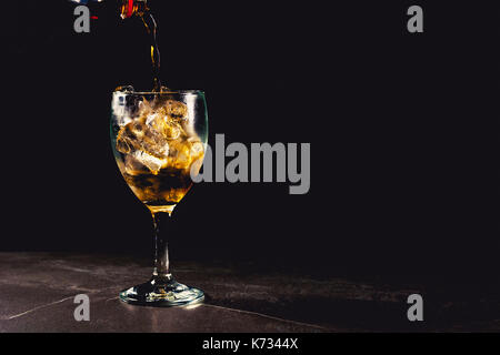 Close up iced cola di vetro. acqua frizzante bibite in bicchiere con ghiaccio su sfondo scuro. Foto Stock