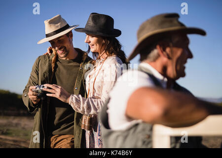 Paio di Riesame di foto sulla fotocamera mentre viaggia nel veicolo durante la vacanza di safari Foto Stock