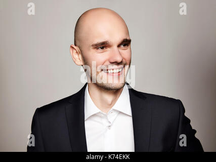 Studio shot del giovane uomo sorridente. formato orizzontale, sorride, indossa una giacca nera. Foto Stock