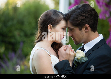 Close up sposa giovane romancing rimanendo in posizione di parcheggio Foto Stock