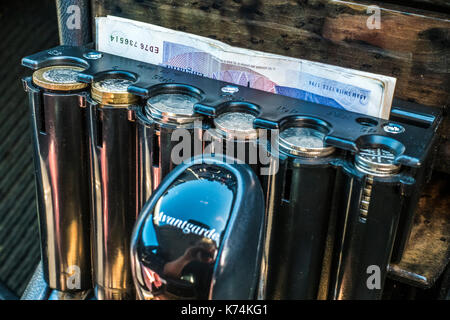 Moneta di plastica contenitore per un taxi, per le varie denominazioni della British denaro / UK sterling monete, come una pronta disponibilità del cambiamento di tariffa. Foto Stock
