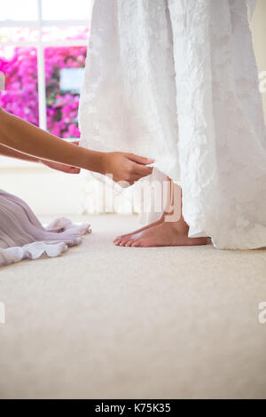 Mani tagliate di regolazione damigella abito da sposa in sala di montaggio Foto Stock